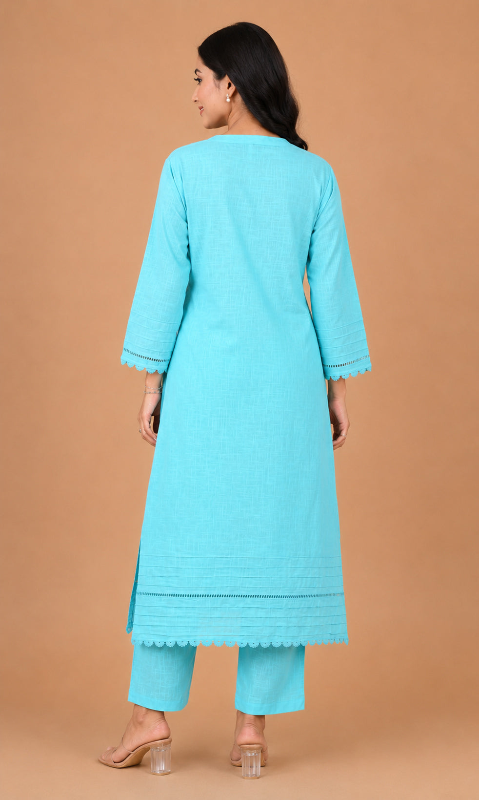 A woman shown from the back wearing a light turquoise blue kurta and matching pants against a solid tan studio background.